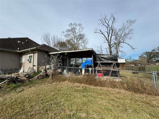 back of house featuring a lawn and a carport