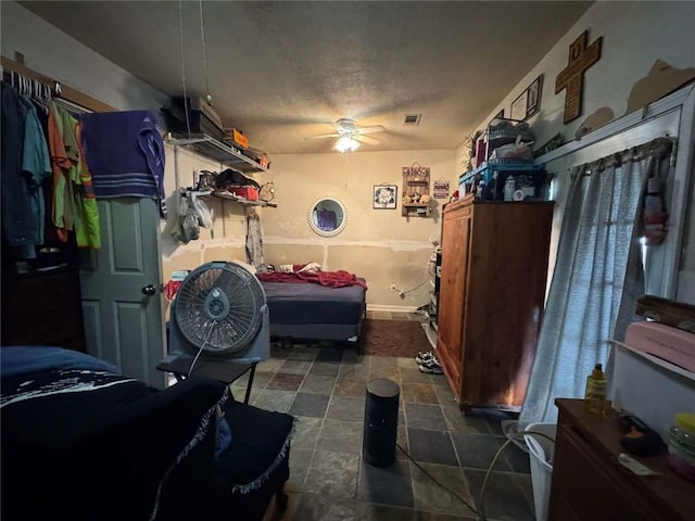 interior space with ceiling fan and a textured ceiling