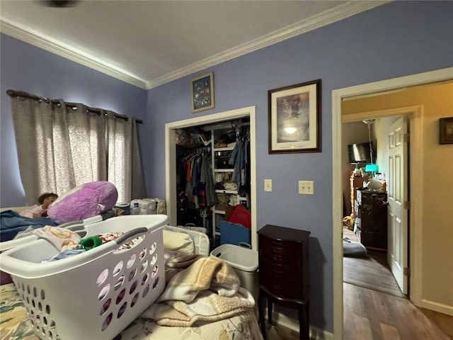 bedroom with dark hardwood / wood-style flooring, a closet, and crown molding