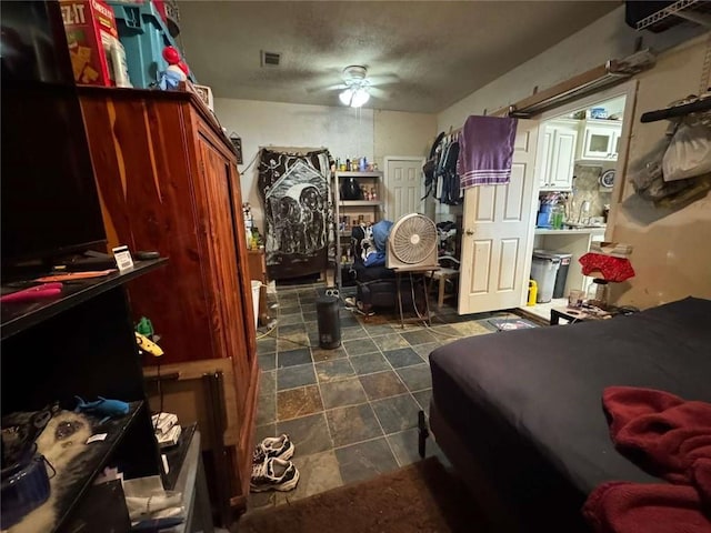 bedroom with ceiling fan and a textured ceiling