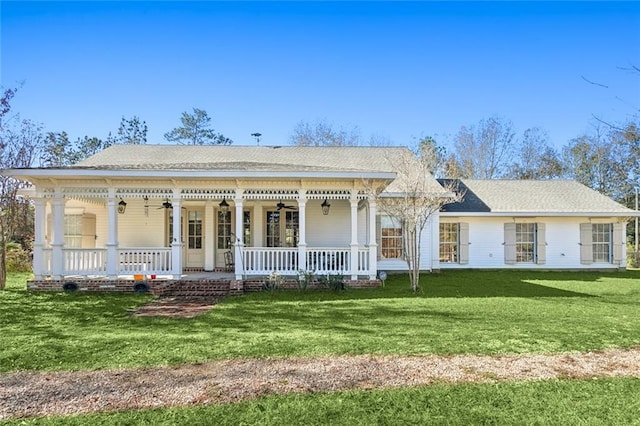 view of front of house with covered porch, ceiling fan, and a front yard