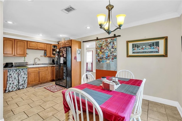 tiled dining room featuring a barn door, ornamental molding, and sink