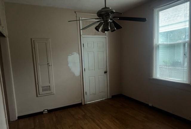 unfurnished bedroom with ceiling fan and dark hardwood / wood-style flooring