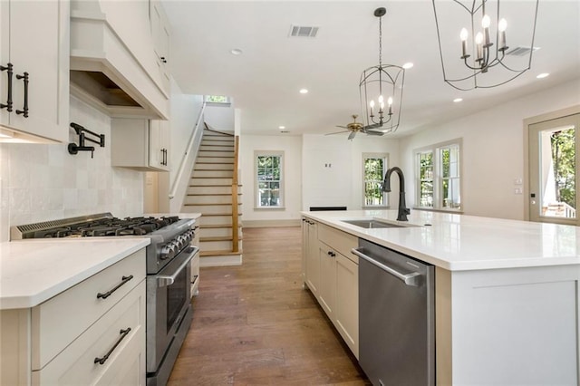 kitchen with decorative backsplash, recessed lighting, appliances with stainless steel finishes, custom exhaust hood, and a sink