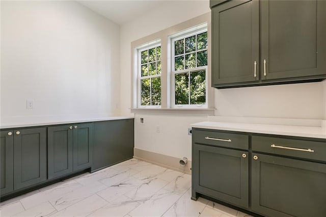 laundry area featuring cabinet space, hookup for an electric dryer, marble finish floor, and baseboards