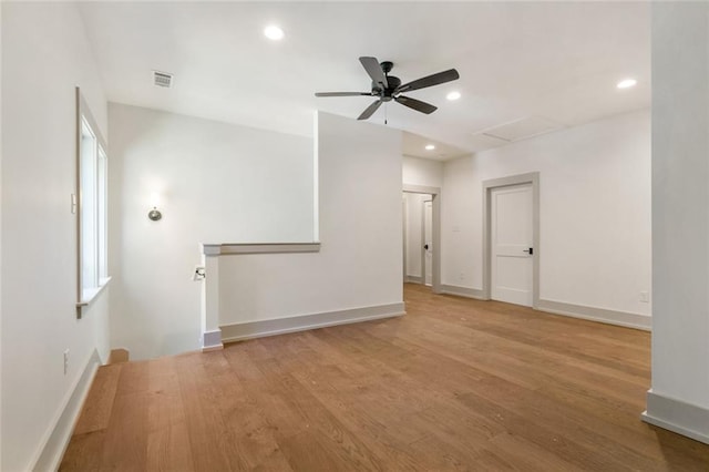 unfurnished room featuring visible vents, baseboards, attic access, light wood-type flooring, and recessed lighting