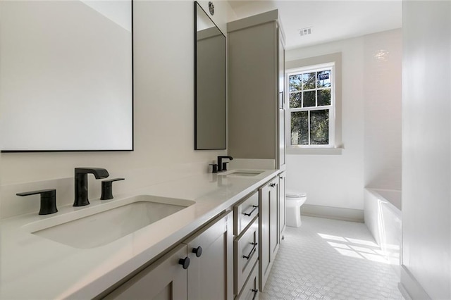 bathroom with double vanity, visible vents, toilet, and a sink