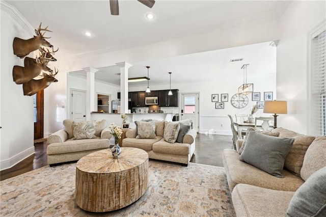 living room with concrete floors, decorative columns, ceiling fan, and crown molding