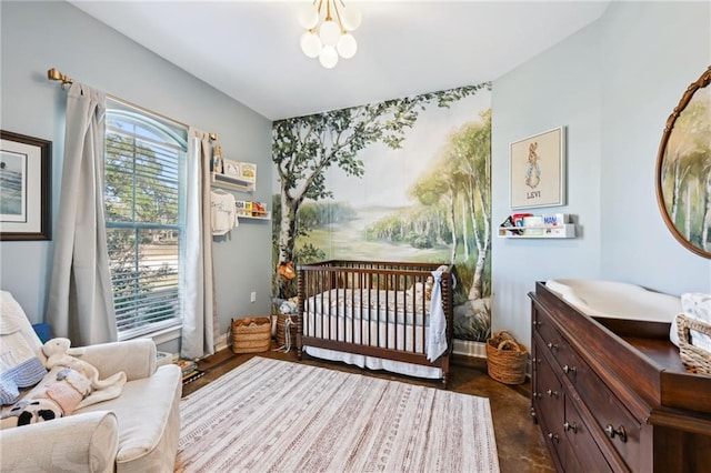 bedroom with a notable chandelier and a nursery area