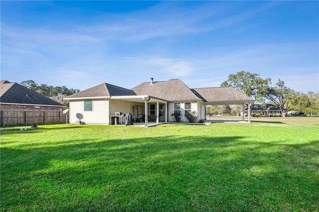 back of house featuring a lawn and a patio area