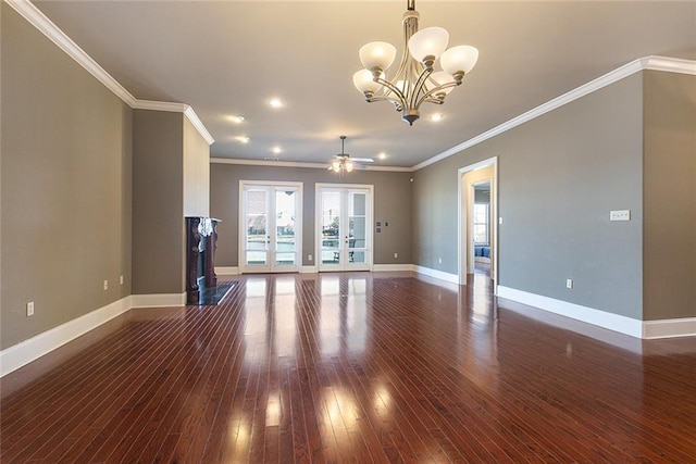 unfurnished living room with dark hardwood / wood-style flooring, ceiling fan with notable chandelier, french doors, and crown molding