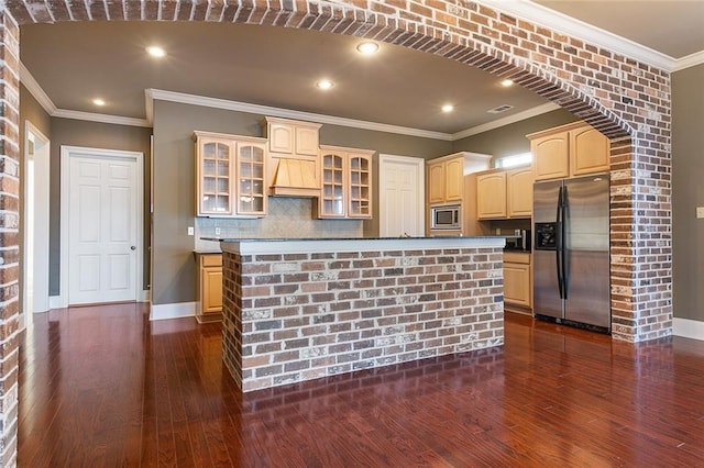 kitchen featuring a center island, ornamental molding, backsplash, and appliances with stainless steel finishes