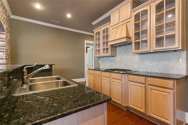 kitchen with premium range hood, dark stone counters, stainless steel gas cooktop, sink, and light brown cabinets