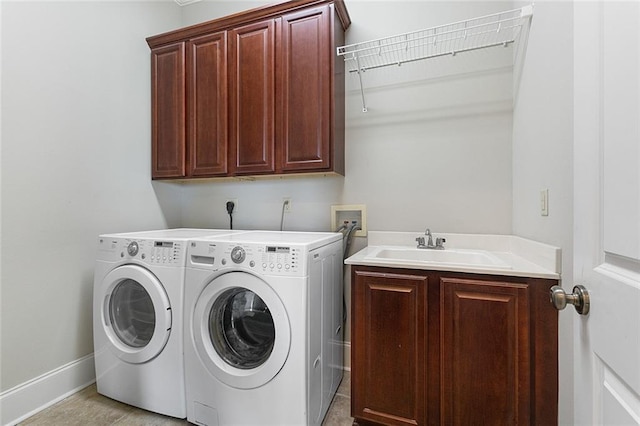 laundry room featuring cabinets, sink, and washing machine and clothes dryer