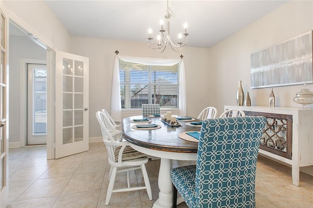 dining room with light tile patterned floors, french doors, and a notable chandelier