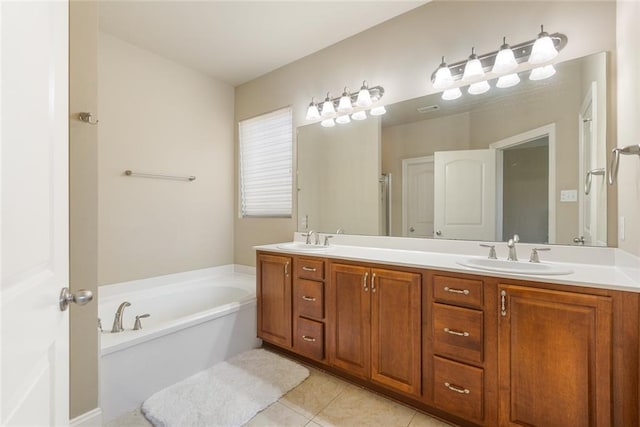 bathroom with a tub, tile patterned flooring, and vanity