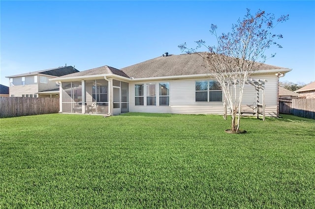 rear view of house with a lawn and a sunroom