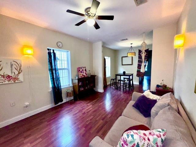 living room with ceiling fan and dark wood-type flooring