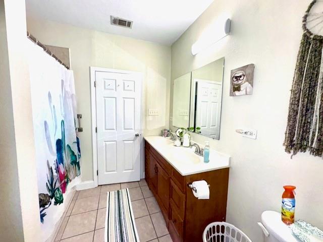 bathroom with tile patterned flooring, vanity, toilet, and a shower with shower curtain