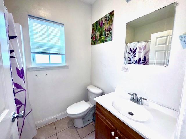 bathroom featuring tile patterned flooring, vanity, a shower with shower curtain, and toilet