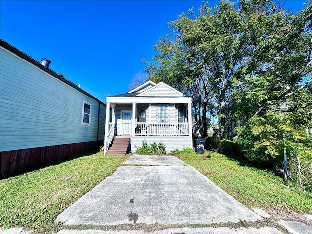 bungalow featuring covered porch and a front lawn