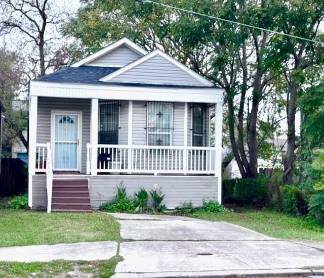 bungalow-style home with a porch and a front lawn