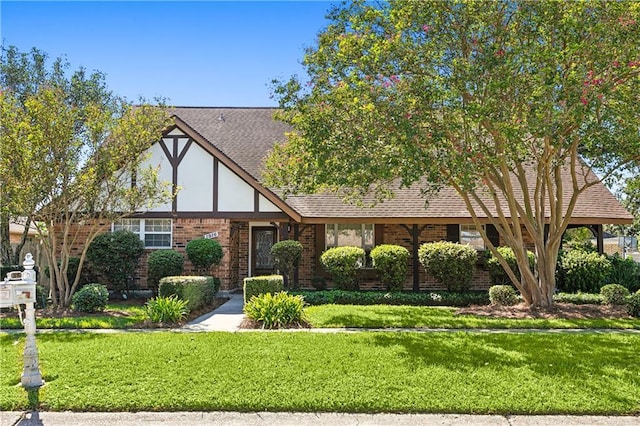 tudor-style house with a front yard