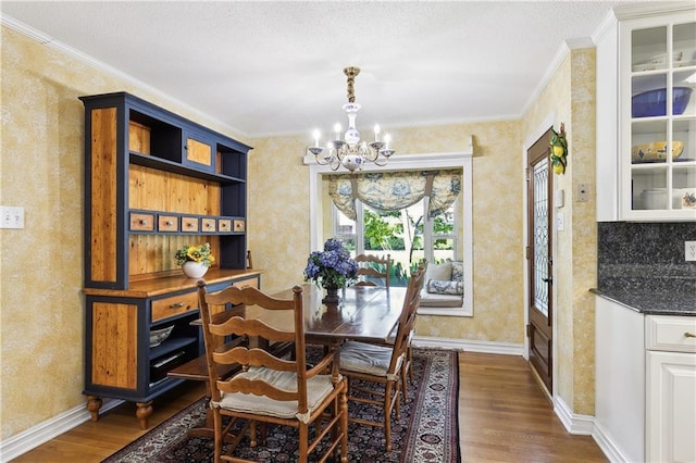 dining area with crown molding, dark hardwood / wood-style flooring, and an inviting chandelier