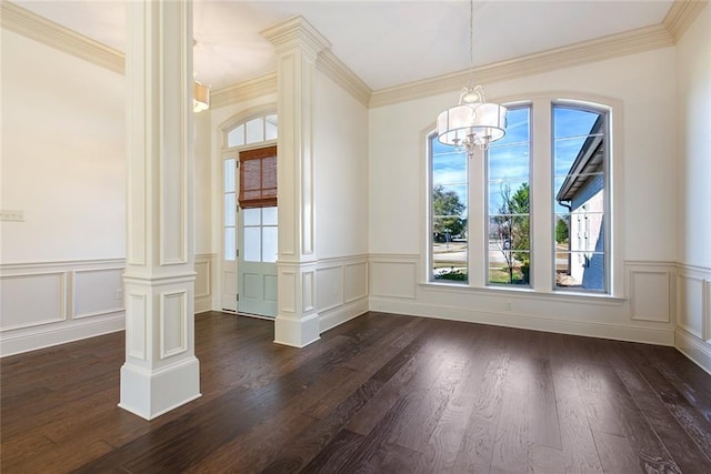 unfurnished dining area with decorative columns, crown molding, dark wood-type flooring, and a notable chandelier