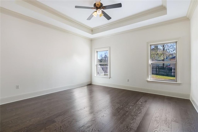 unfurnished room featuring dark hardwood / wood-style flooring, ceiling fan, a raised ceiling, and ornamental molding