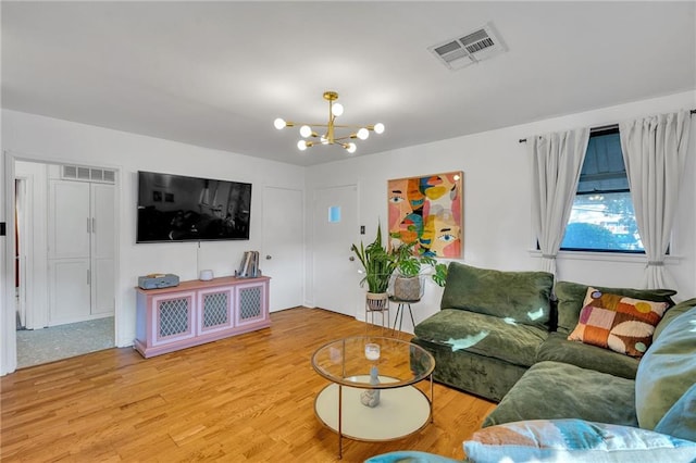 living room featuring wood-type flooring and an inviting chandelier