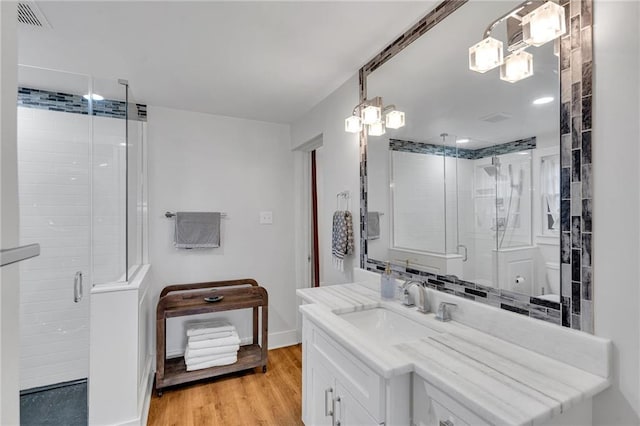 bathroom featuring hardwood / wood-style floors, vanity, toilet, and walk in shower