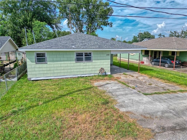 rear view of house with a yard and a carport