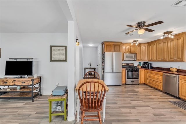 kitchen featuring ceiling fan, light hardwood / wood-style floors, and stainless steel appliances