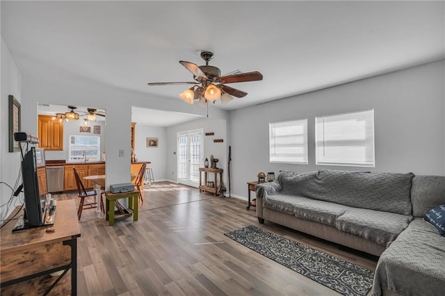 living room featuring ceiling fan, sink, and hardwood / wood-style flooring