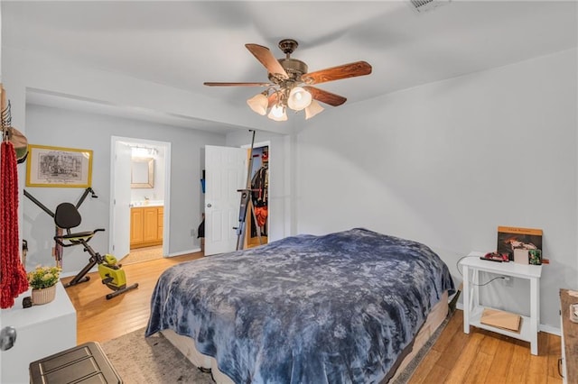 bedroom with hardwood / wood-style floors, ceiling fan, and ensuite bathroom