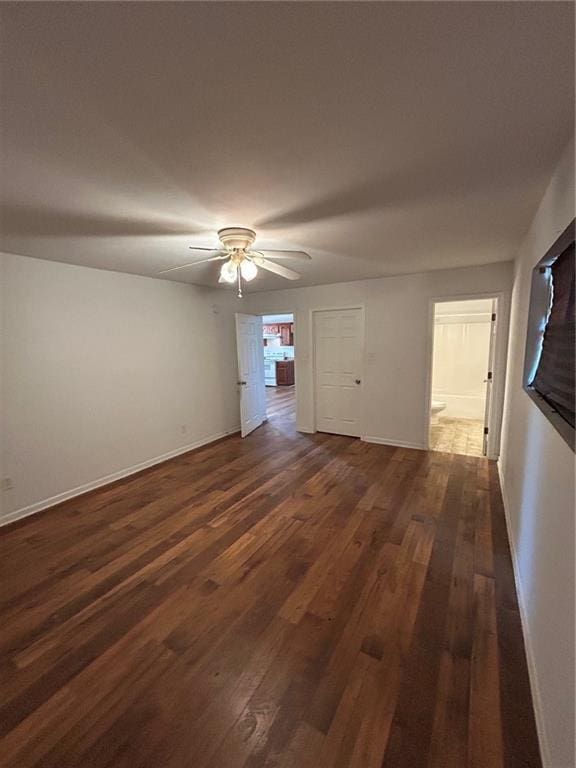 empty room with ceiling fan and dark hardwood / wood-style flooring