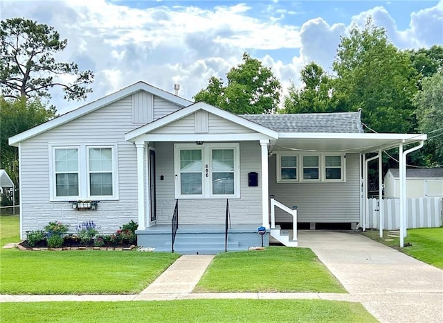 view of front of home with a front lawn, covered porch, and a carport