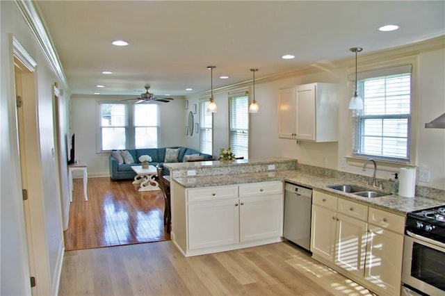 kitchen with kitchen peninsula, sink, light hardwood / wood-style flooring, appliances with stainless steel finishes, and white cabinetry