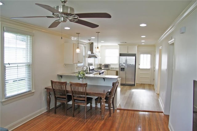 dining room with a wealth of natural light, ceiling fan, light hardwood / wood-style flooring, and ornamental molding