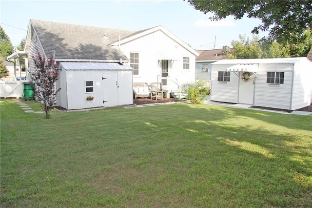 back of property featuring a yard and a shed