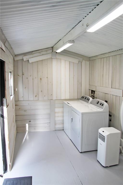 washroom featuring separate washer and dryer and wooden walls