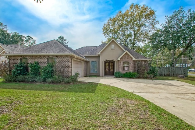 single story home with french doors, a garage, and a front lawn