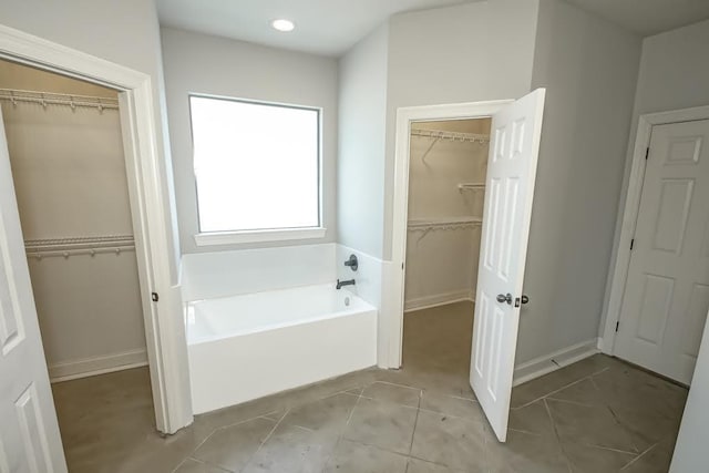 bathroom featuring tile patterned floors and a tub to relax in