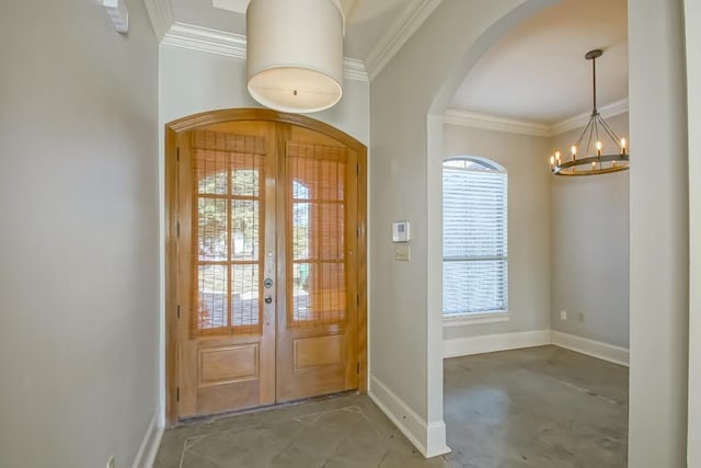 entrance foyer featuring crown molding, french doors, and an inviting chandelier