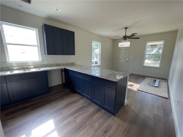 kitchen featuring ceiling fan, wood-type flooring, kitchen peninsula, and sink