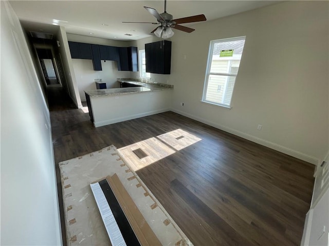 kitchen featuring kitchen peninsula, ceiling fan, and dark wood-type flooring