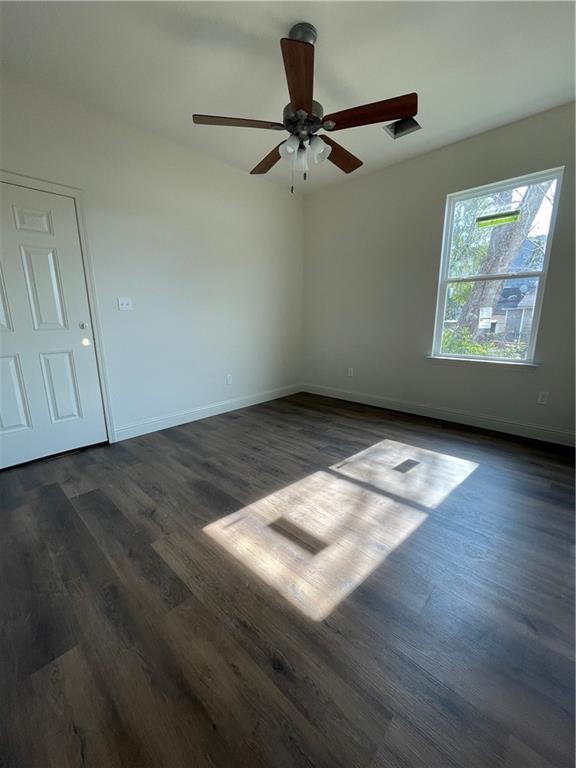 unfurnished room featuring dark hardwood / wood-style flooring and ceiling fan