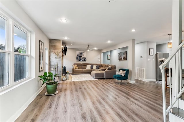 living room with ceiling fan and light wood-type flooring