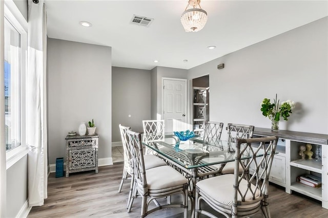 dining room with hardwood / wood-style flooring and an inviting chandelier